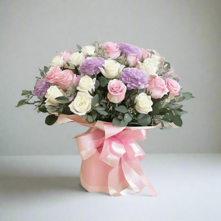 Bouquet with 10 white roses, 10 pink roses, 4 purple roses, eucalyptus, pink wrapping, and pink bow by florist dubai