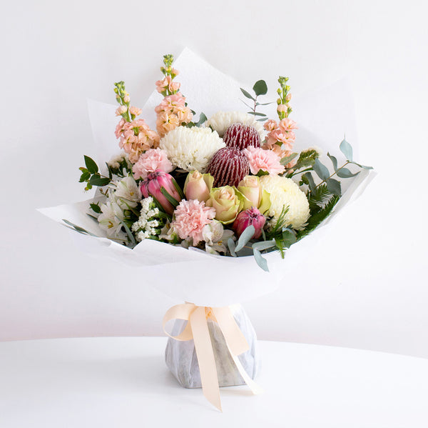 Proteas, white decco, carnations, roses, mathiola, and eucalyptus by florist dubai.