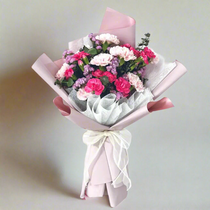 Fuschia pink carnations, lite pink carnations, purple statice, and eucalyptus by florist dubai.