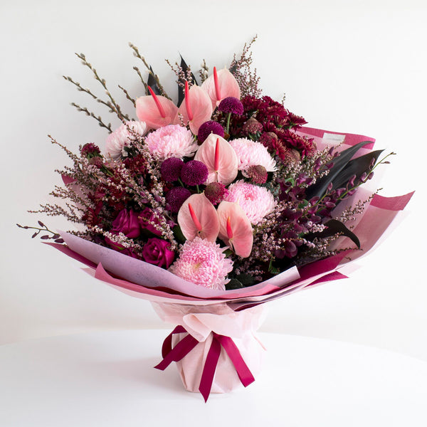 Pink anthuriums, pink decco, pink limonium, dark pink roses, and button chrysanthemums by florist dubai.